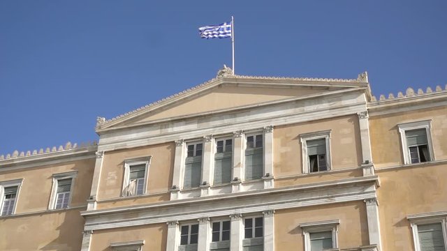 waving flag on the Greek parliament building in Athens, Greece