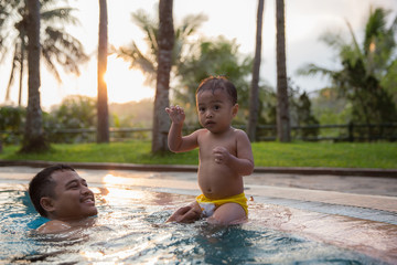father and son enjoying pool