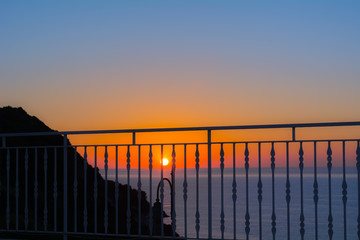 Tramonto sul mare con montagna in controluce