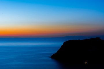 Tramonto sul mare con montagna in controluce