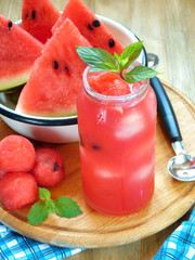 Watermelon segments and a refreshing drink with ice and decorated with mint