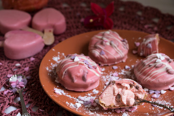 Mit rosa Zuckerguss überzogene kleine runde Törtchen