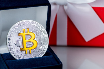 Christmas gift or New Year with ribbon and best gift bitcoin coin on light background. Cryptocurrency investition concept