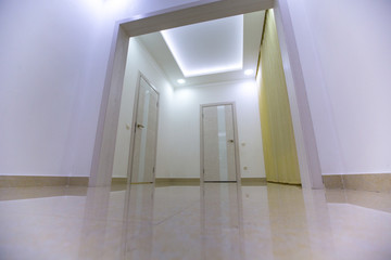 corridor of a house with white walls with doors