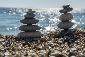 Fototapeta na wymiar Stones and pebbles stack, harmony and balance, two stone cairns on seacoast
