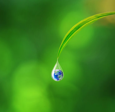 Earth in water drop reflection under green leaf, Elements of this image furnished by NASA