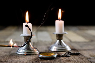 candles burning in candlesticks on a wooden table. Silver candlesticks.