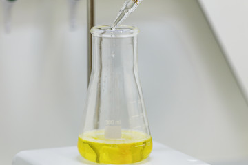 Professional laboratory, dropping liquid into a glass