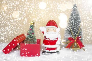 Miniature Christmas Santa cros and Tree on snow over blurred bokeh background,Decoration Image for Christmas Holiday and Happy New Year Gift box Celebration concept.
