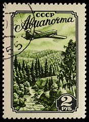 Aircraft over taiga on postage stamp