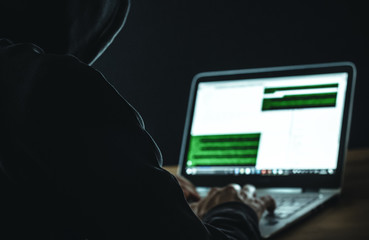 Mann mit Kapuzenpullover beim Hacken.
