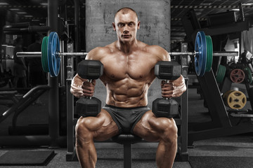 Fototapeta na wymiar Muscular man with dumbbells in gym, bodybuilder. Strong male naked torso abs, working out