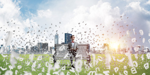 Young businessman or student studying the science and symbols fly around