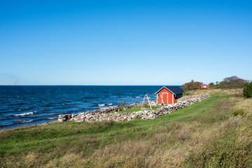 Traditional red cottage during autumn on Swedish Baltic sea island Oland. Oland is a popular tourist destination in Sweden during summertime.