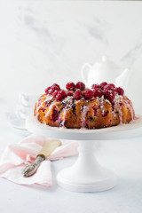  Lemon bundt-cake with raspberries on a light background. Selective focus.