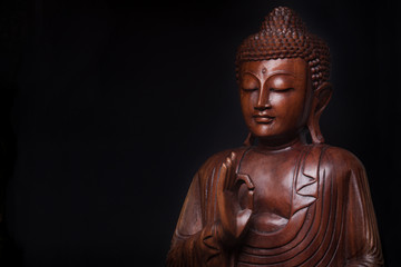 Bouddha, avec la main levée en geste de vitarka mudra.