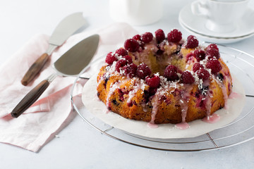  Lemon bundt-cake with raspberries on a light background. Selective focus.