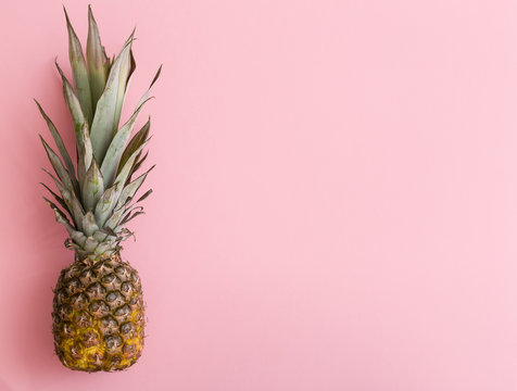 Closeup of fresh organic pineapple on light pink background.