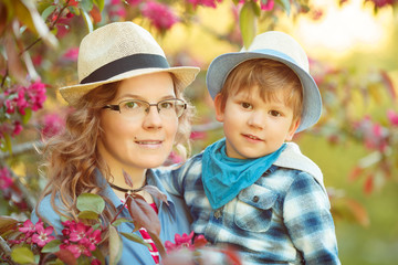 Obraz premium Mom and son have fun in the park. Tenderness, hugs and joy outside the room. Mothers Day.