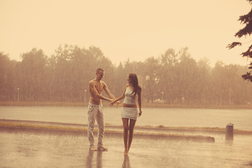 Loving couple in the rain barefoot. A man and a woman in love.