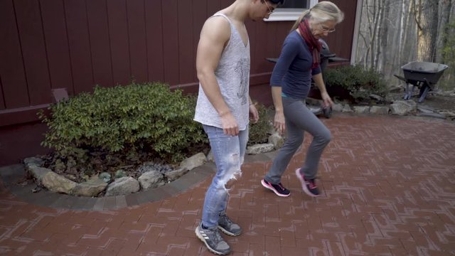 Mother teaching her son a dabke step to learn the middle eastern folk dance.