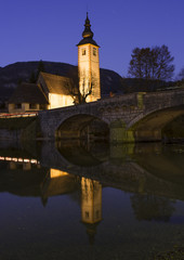 Bohiji Lake and Church of St. John the Baptist with arched bridge and reflection in dusk time, Triglav National Park,  Julian Alps, Slovenia