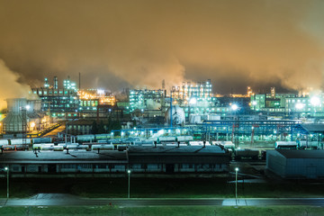Fototapeta na wymiar Oil refinery with pipes and distillation complexes at night