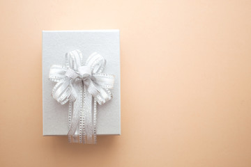 silver color gift box with bow ribbon on background top view