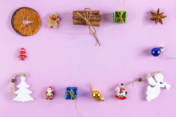 MERRY CHRISTMAS COMPOSITION IN FRAME ON PINK BACKGROUND. HOLIDAY DECOR ON FLAT LAY
