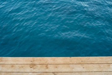 Top view deep blue sea and wooden floor of a pier.