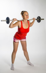 Girl with a barbell on a white background.