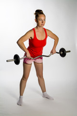 Obraz premium Girl with a barbell on a white background.