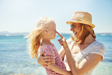 Young female holding little daughter on hands