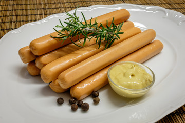 Sausages (Frankfurter) on rustic background with dijon mustard, photographed with natural light (Selective Focus)