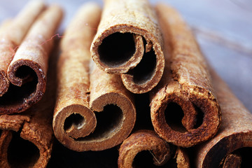 Ground cinnamon, cinnamon sticks, on old wooden background in rustic style.