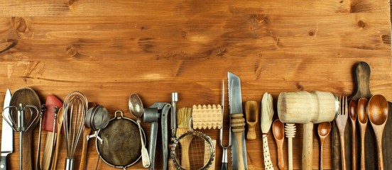 Old kitchen utensils on a wooden board. Sale of kitchen equipment. Chef's tools. - Powered by Adobe