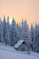 Winter landscape with wooden house in the mountains