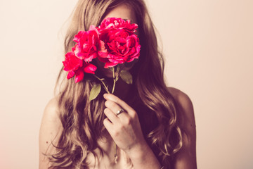 Woman holding a rose bouquet in front of her face