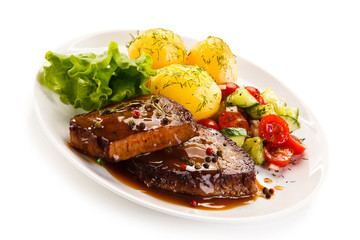 Grilled steak with vegetables on white background 