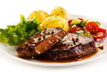 Grilled steak with vegetables on white background 