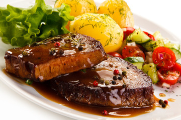 Grilled steak with vegetables on white background 