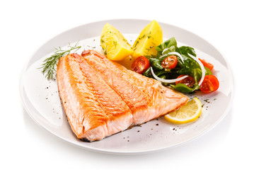 Fried salmon and vegetables on white background 