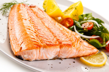 Fried salmon and vegetables on white background 