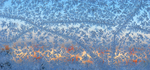 Picture of ice crystals on glass on background of sunset