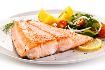 Fried salmon and vegetables on white background 