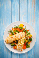 Fish dish - fried fish fillet and vegetables on white background 