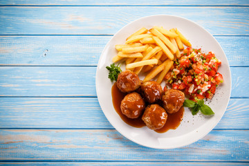 Roasted meatballs, chips and vegetables 