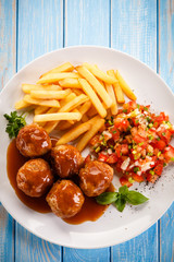 Roasted meatballs, chips and vegetables 
