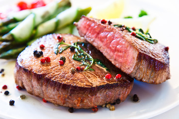 Grilled beefsteak with asparagus on white background 