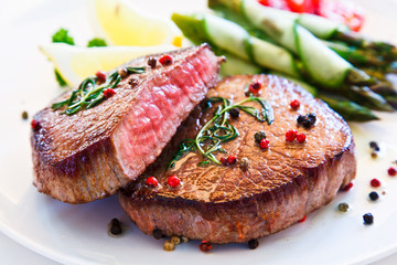 Grilled beefsteak with asparagus on white background 